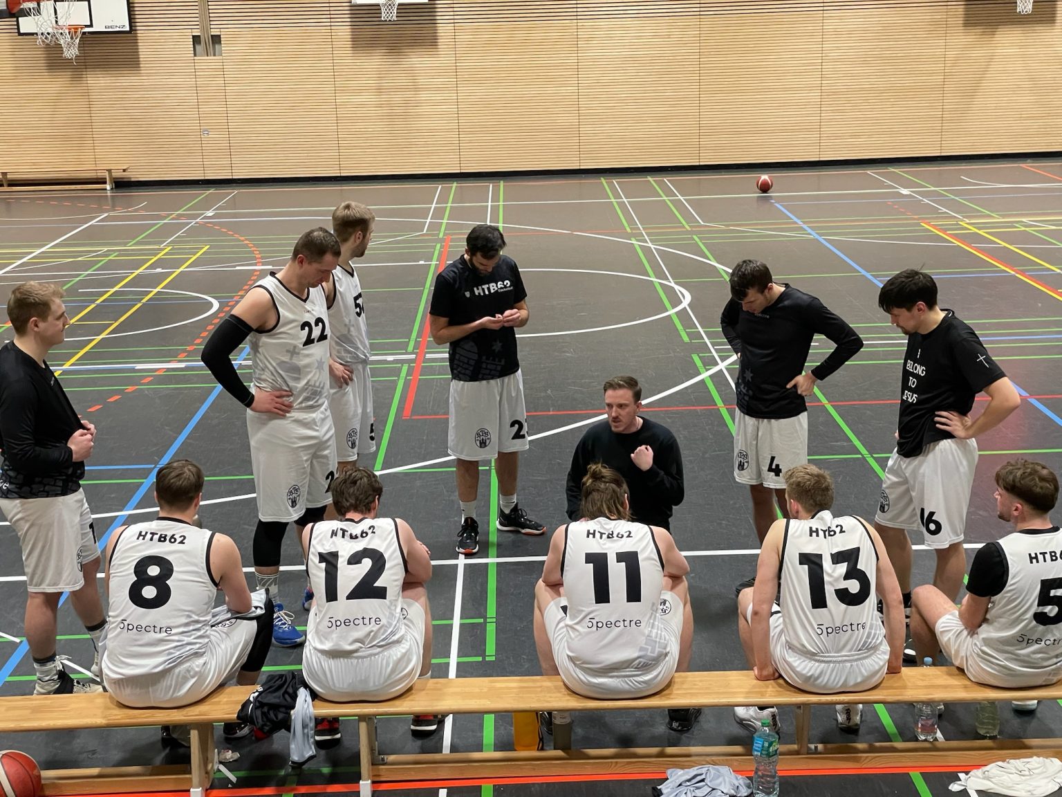 Spieler in weißen Trikots auf der Auswechselbank während eines Spiels